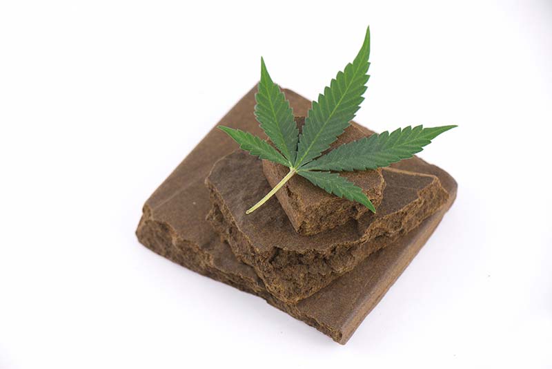 Small block of hash with cannabis leaf